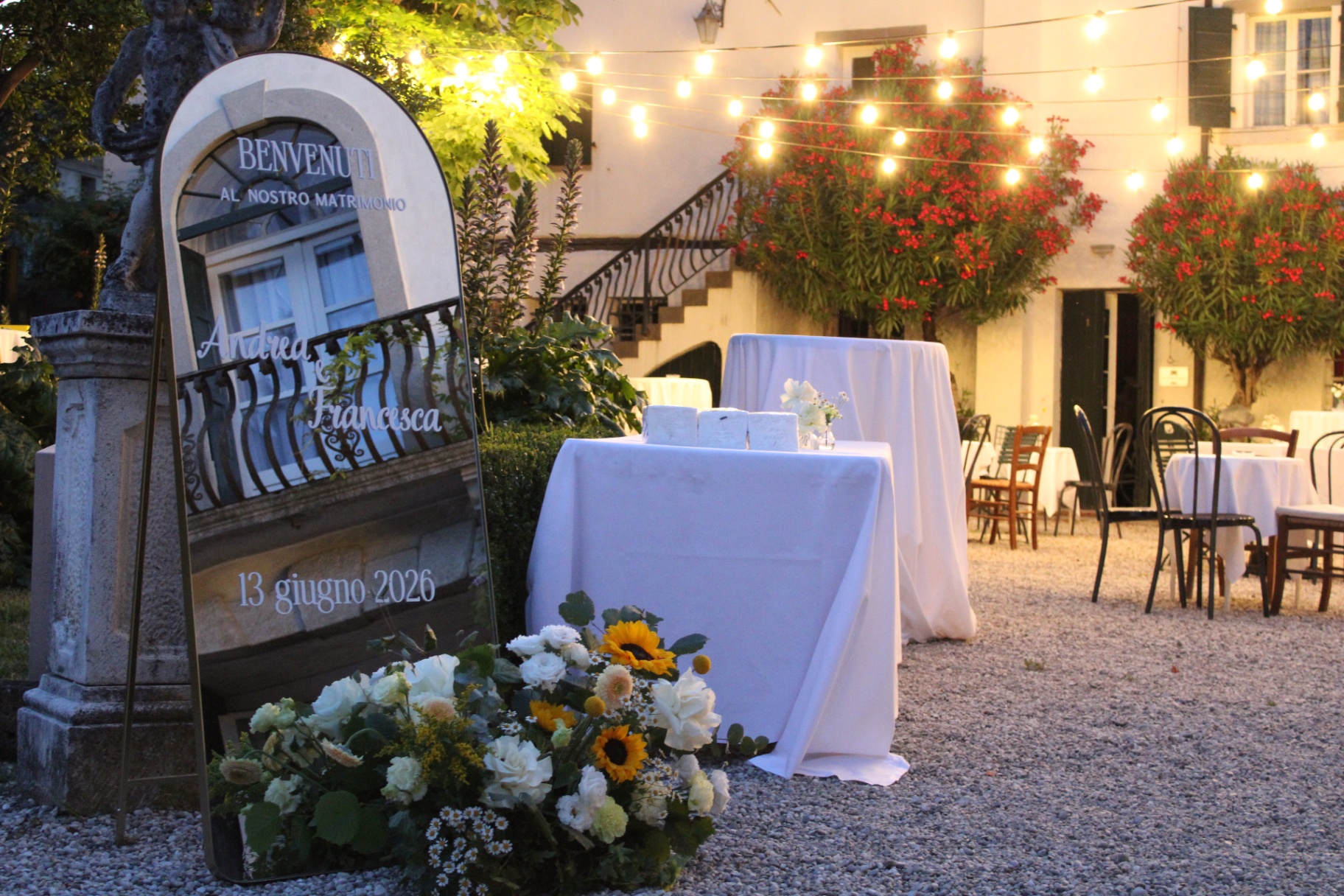 Allestimento matrimoniale nella corte al tramonto con luminarie