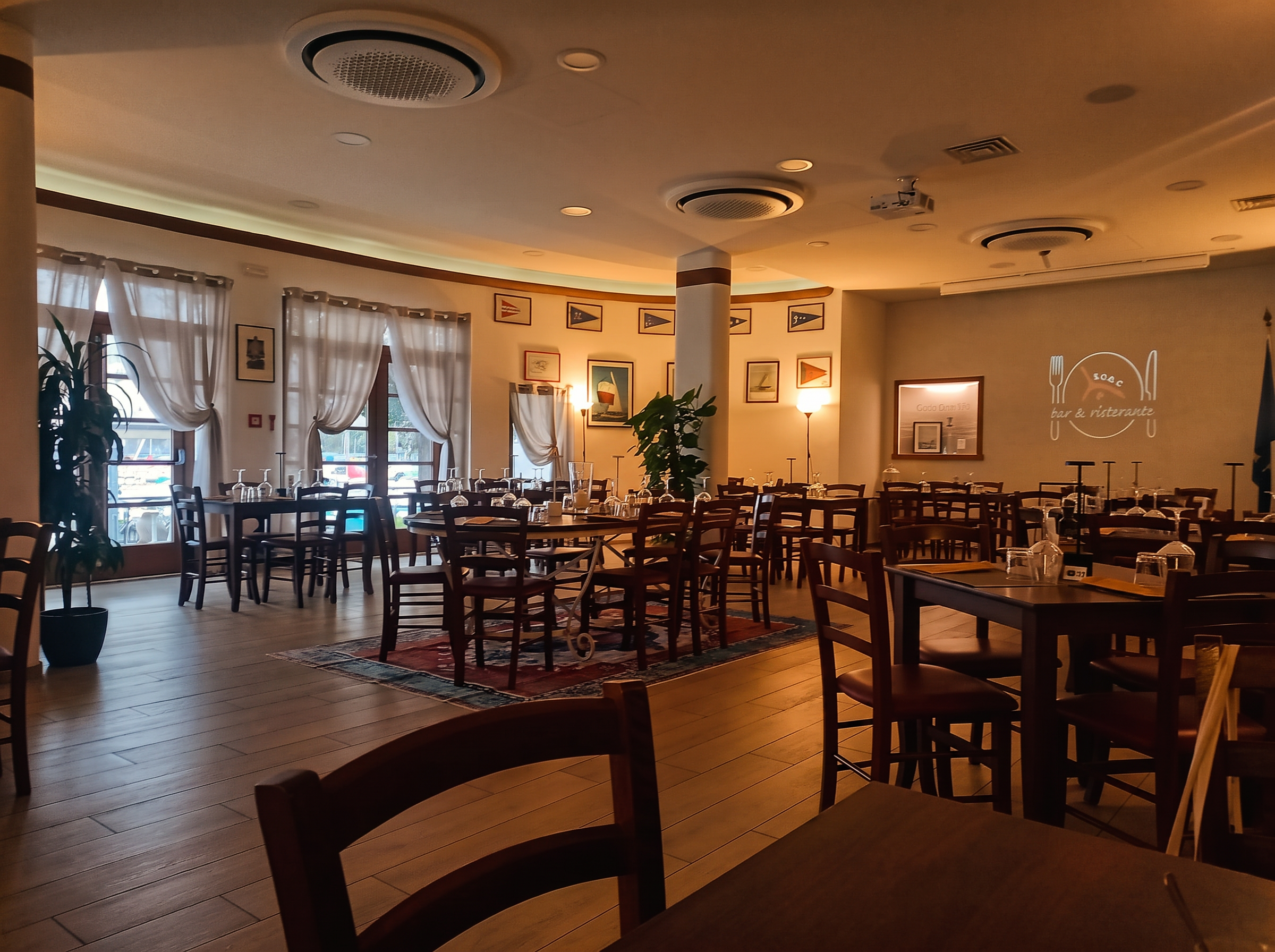 Sala interna del ristorante SVOC con stampe e guidoni velici